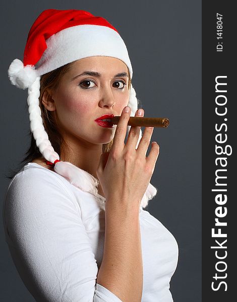 Brunette wearing a santa hat smoking a cigar. Brunette wearing a santa hat smoking a cigar