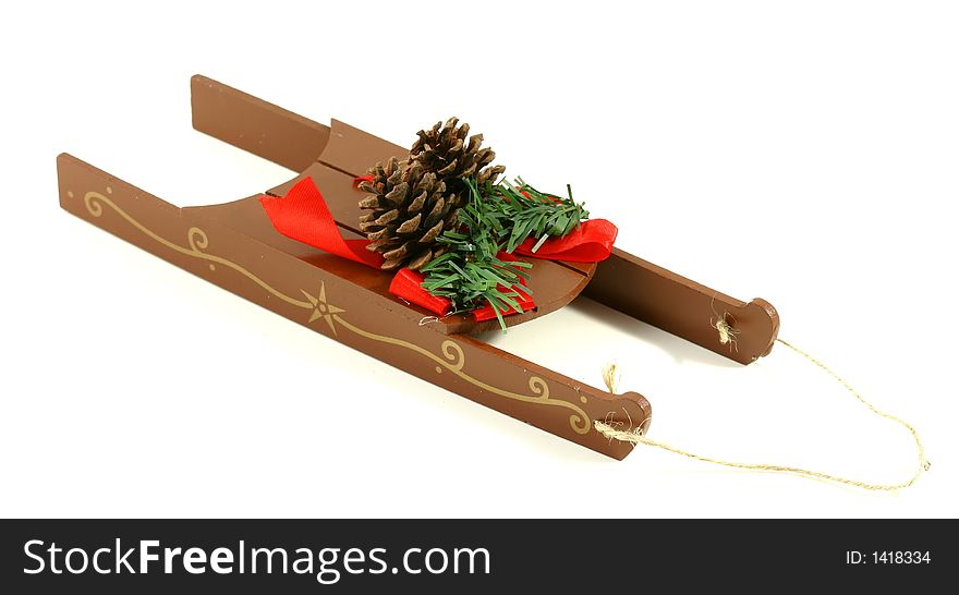 A simple, decorative, christmas sled with pine cones, ribbon, and greenery