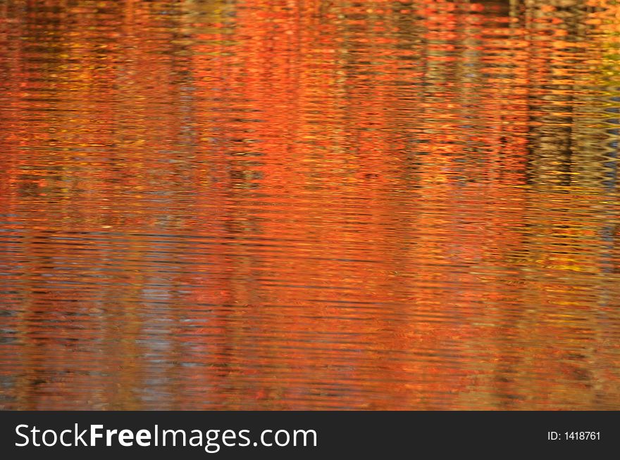 Autumn colors reflected in moving lake water. Autumn colors reflected in moving lake water