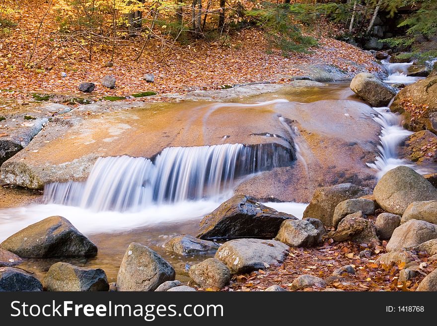 Autumn river flows over smooth rocks. Autumn river flows over smooth rocks.