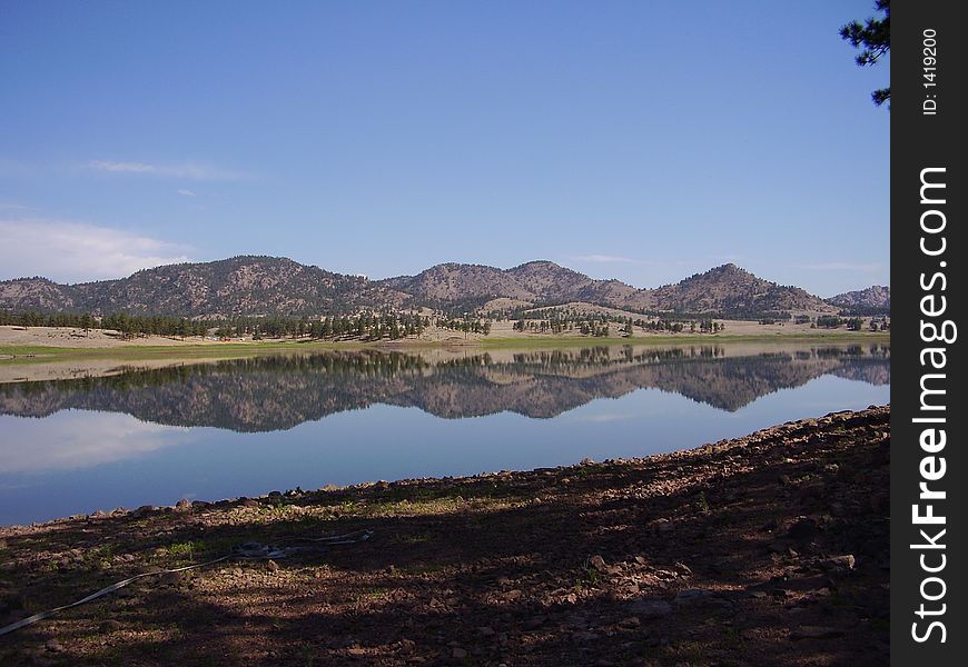 A series of hills reflected on a lake. A series of hills reflected on a lake