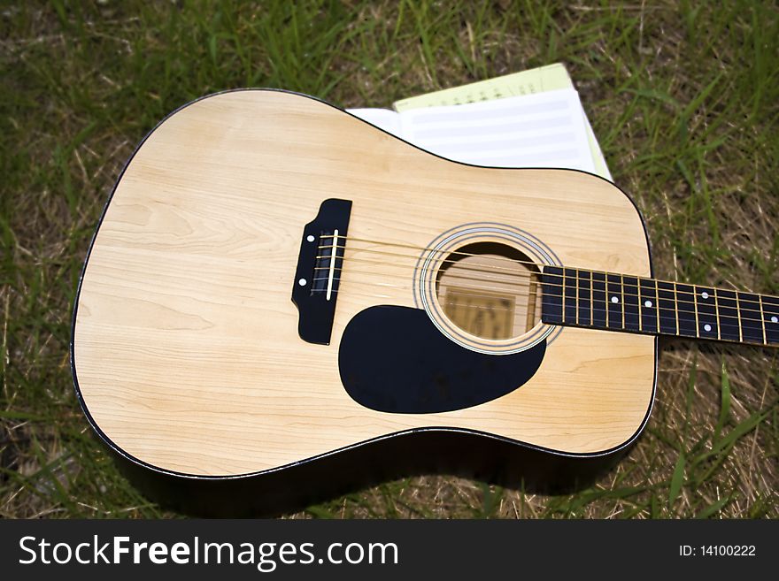 A musical instrument, guitar on the grass. A musical instrument, guitar on the grass