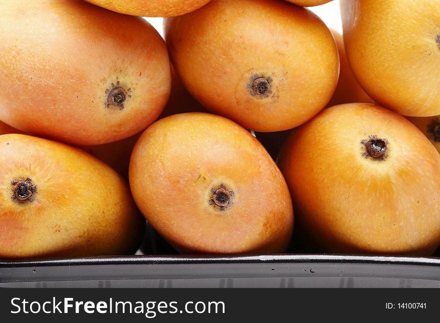 Close-up of fresh mangoes in dark box. Close-up of fresh mangoes in dark box.