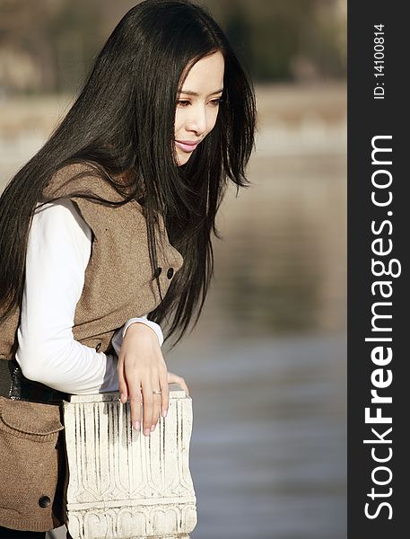 Young Asian woman pondering by the river. Young Asian woman pondering by the river.