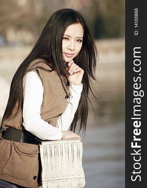 Young Asian girl pondering by the river. Young Asian girl pondering by the river.