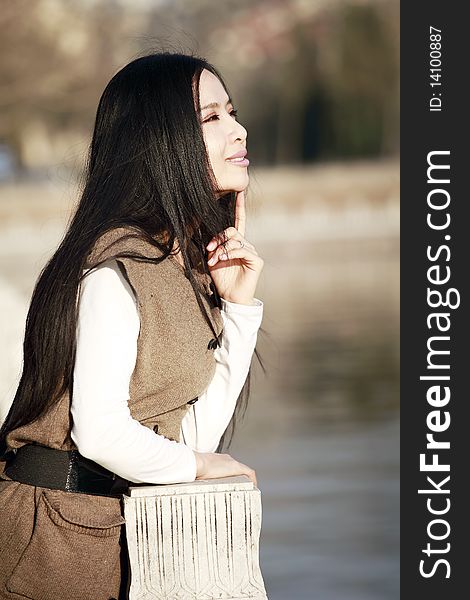 Asian girl enjoying spring scenery by the river. Asian girl enjoying spring scenery by the river.