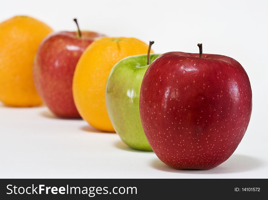 Close-up of a row of apples and oranges.