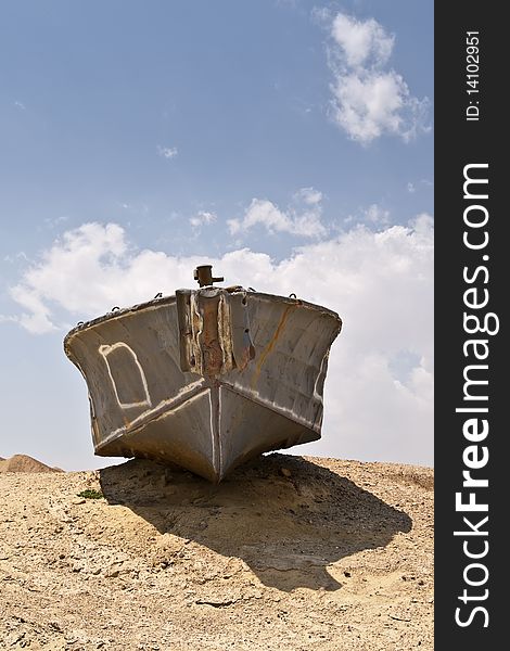 Abandoned shipwreck of steel boat in desert against blue sky. Abandoned shipwreck of steel boat in desert against blue sky