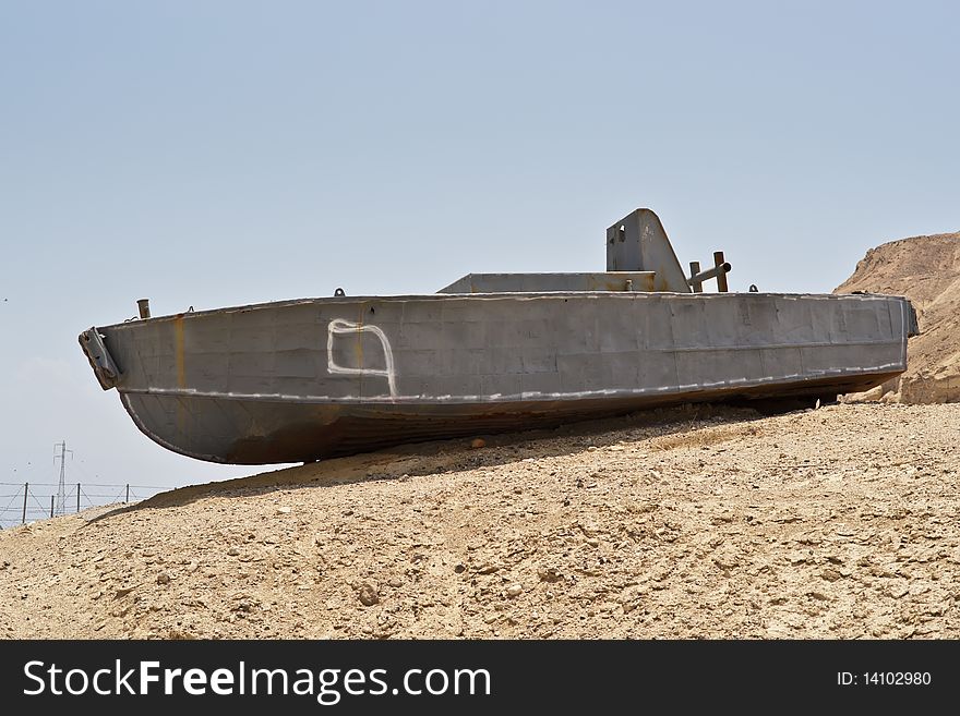 Abandoned shipwreck of steel boat in desert against blue sky. Abandoned shipwreck of steel boat in desert against blue sky