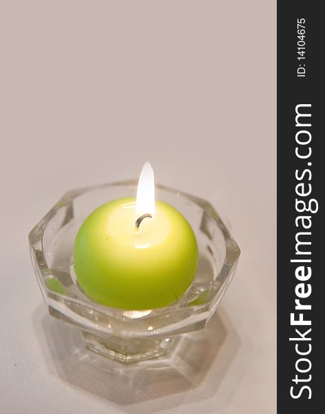 Burning green candles on white background
