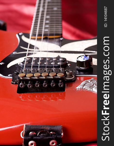 Close-up on an electric guitar on red satin background. Close-up on an electric guitar on red satin background