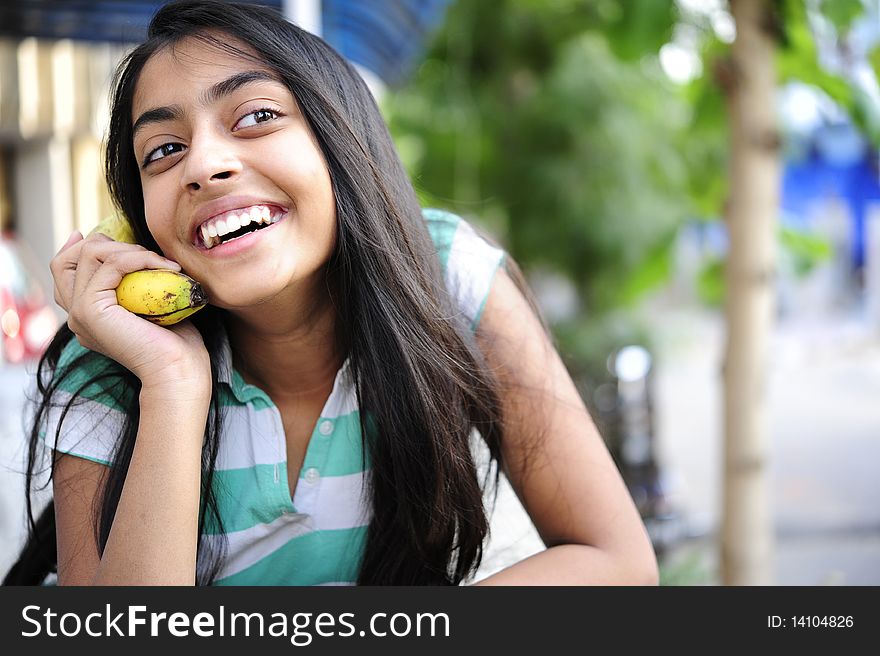 Girl giving talking expression with banana. Girl giving talking expression with banana