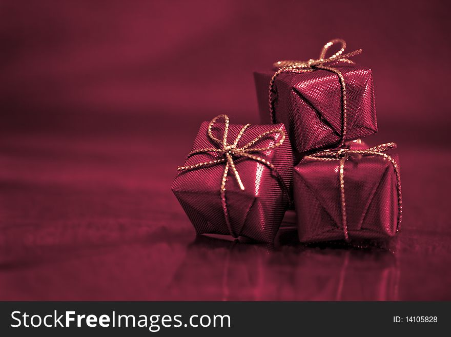 Close-up photograph of three small red gift boxes on an abstract red background. Close-up photograph of three small red gift boxes on an abstract red background.