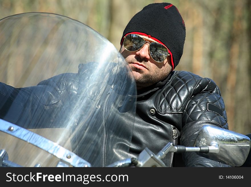 Biker sitting on his motorcycle , bright