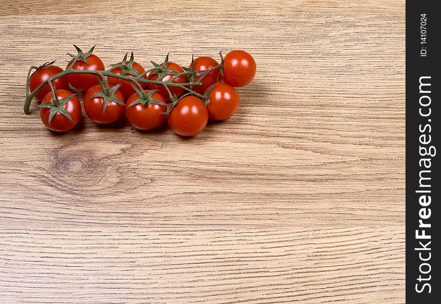 Little tomatoes on a wooden background