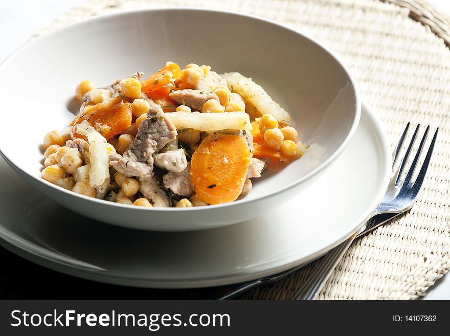 Pork meat on celery with carrot and chick peas