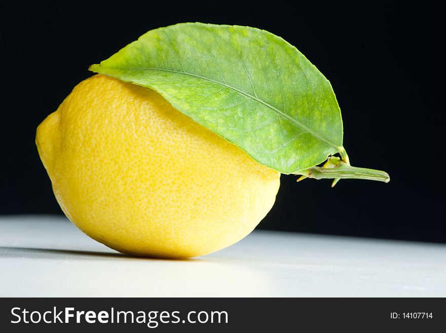 Yellow lemon with a leaf