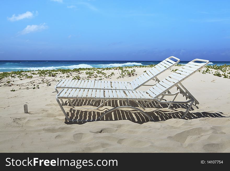 Profile view of a pair of beach lounge chairs on one of Barbados beautiful beaches. Profile view of a pair of beach lounge chairs on one of Barbados beautiful beaches.