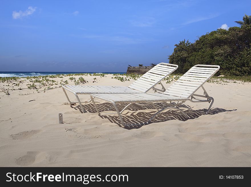 Profile view of a pair of beach lounge chairs on one of Barbados beautiful beaches. Profile view of a pair of beach lounge chairs on one of Barbados beautiful beaches.