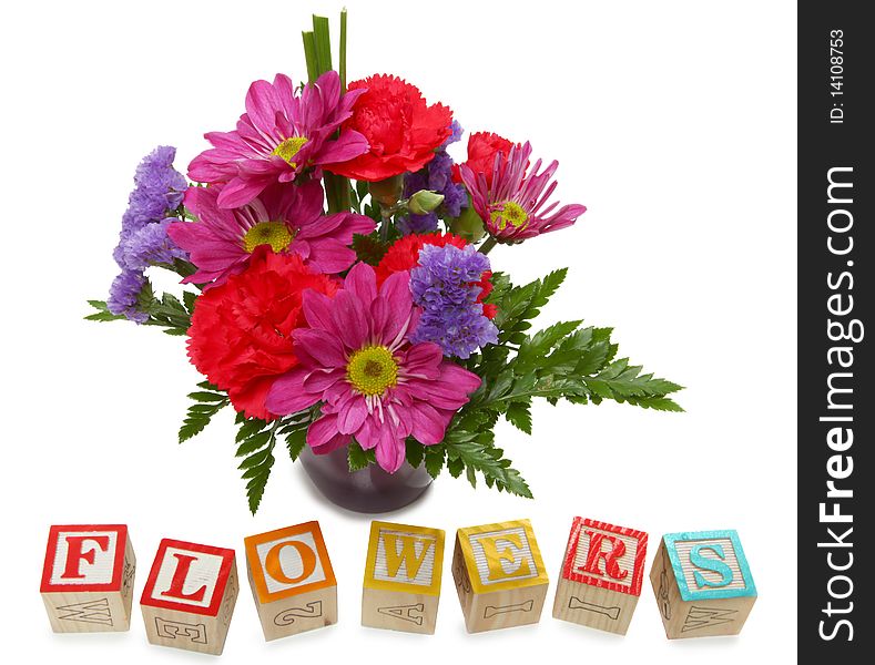 Small bouquet of flowers with alphabet blocks spelling flowers over white. Small bouquet of flowers with alphabet blocks spelling flowers over white.