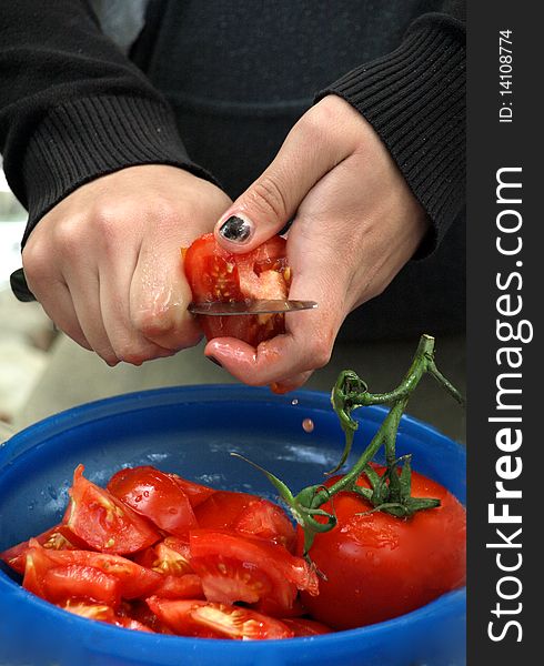 Woman is cutting tomato  on the barbecue