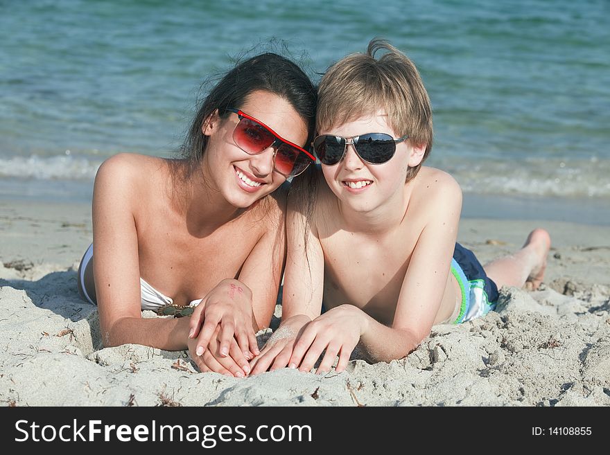 Young teenagers lying on the sand enjoying Miami Beach. Young teenagers lying on the sand enjoying Miami Beach.