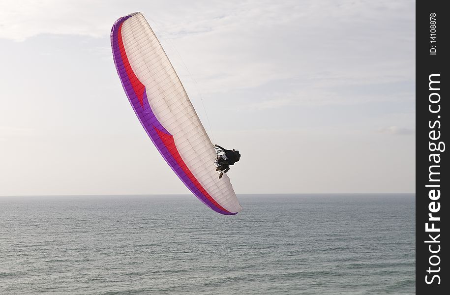 Two Paragliders making aerobatics with Paraglid over the sea. Two Paragliders making aerobatics with Paraglid over the sea