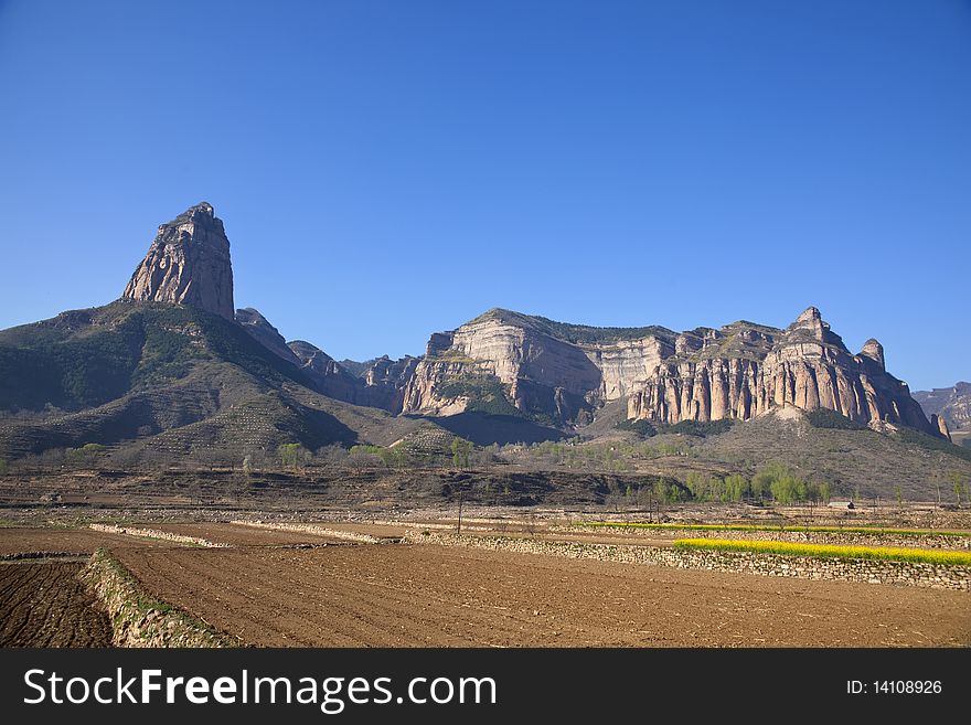 The uncultivated fields at the foot of the rocky mountains in China. The uncultivated fields at the foot of the rocky mountains in China