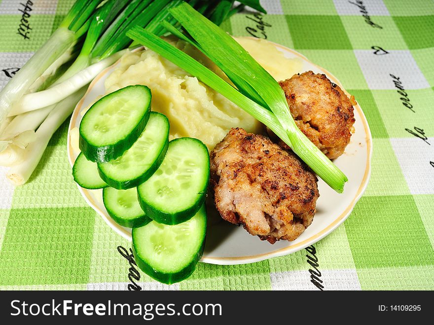 Image fried cutlets on a white dish with fresh cucumbers