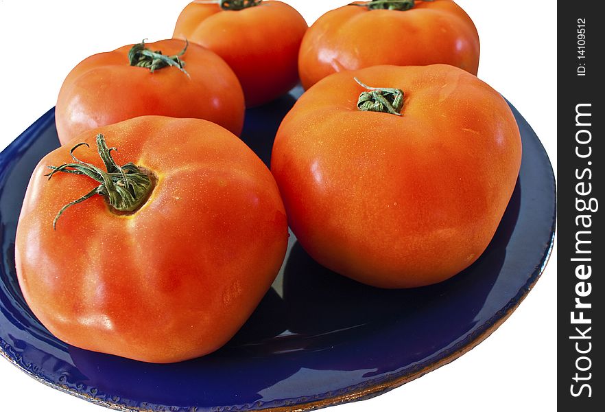 Tomatoes isolated on a blue plate shot from an angle. Tomatoes isolated on a blue plate shot from an angle
