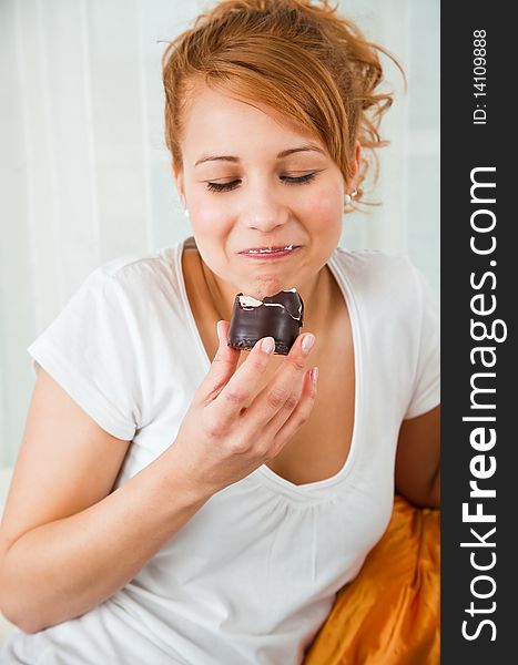 Young, beauty girl eating chocolate cake an smiling