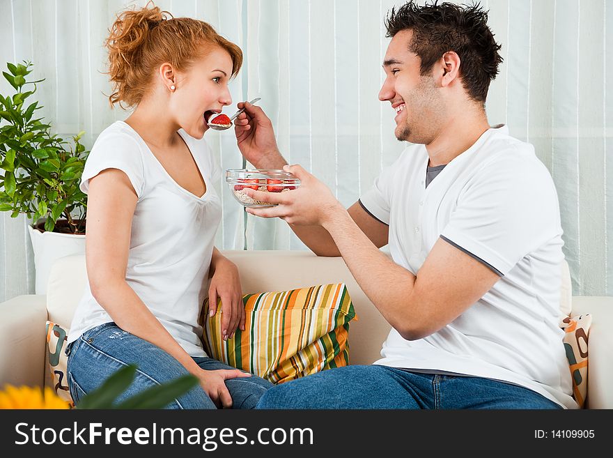 Handsome boy feeding a young, beauty girl strawberry. Handsome boy feeding a young, beauty girl strawberry