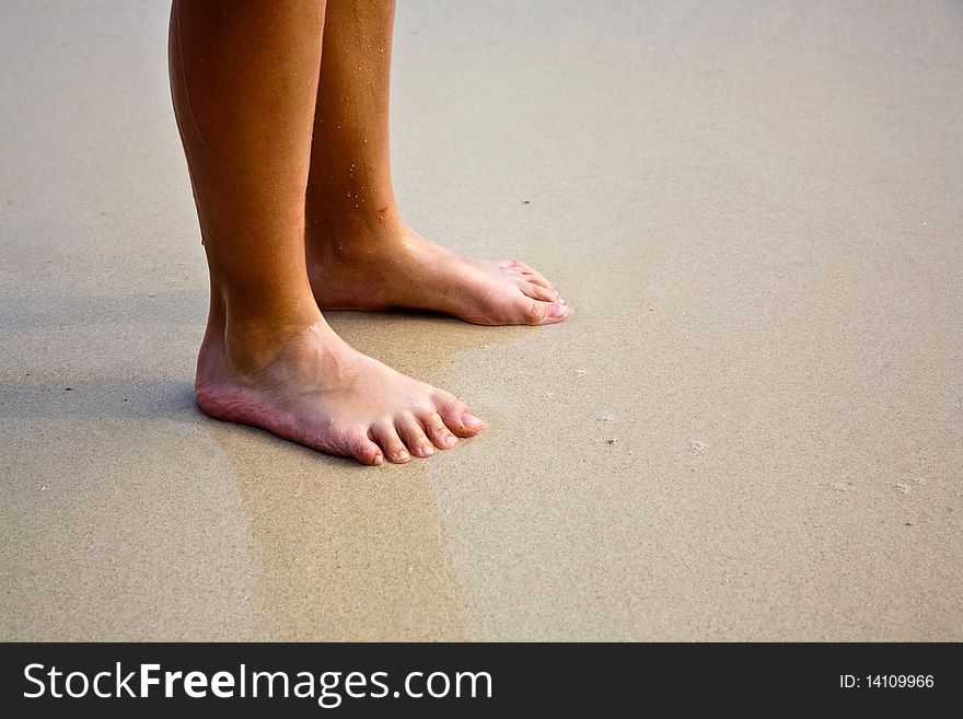 Feet on the beautiful sandy beach. Feet on the beautiful sandy beach