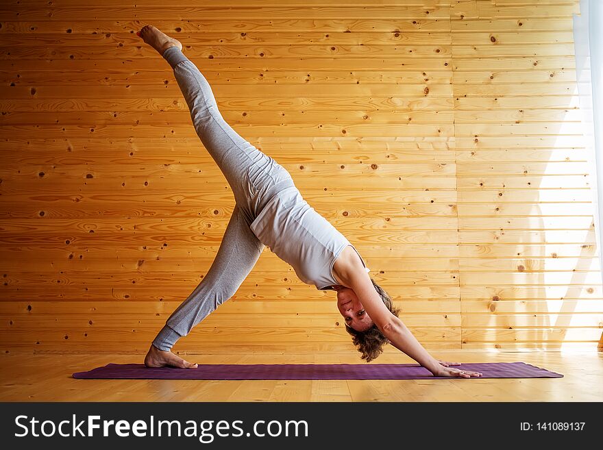 Caucasian Woman Is Practicing Yoga At Studio