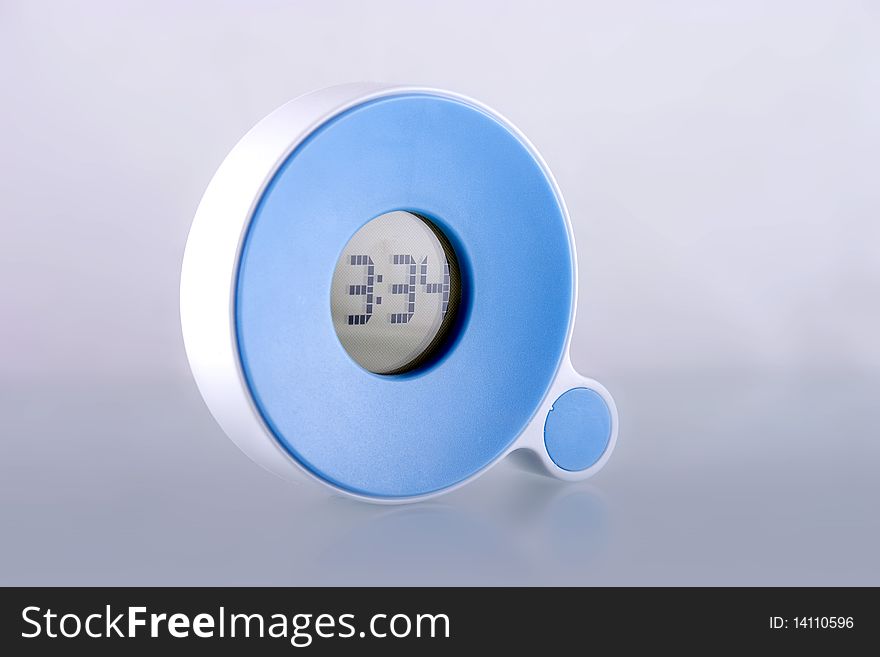 Modern electronic clock on gray background.