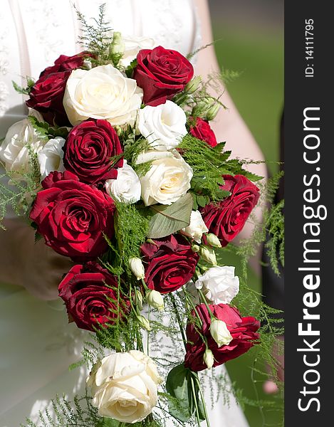 Bride holds bridal bouquet with roses in hand