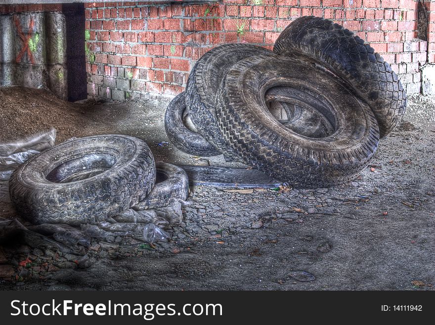 A pack of old tires and lot of rubbish around