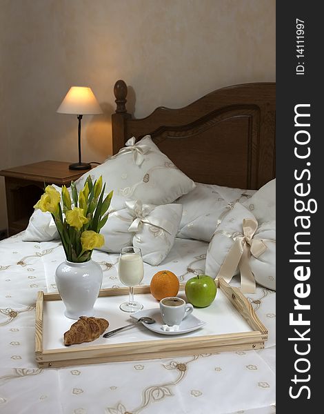 Tray with breakfast on a bed in a hotel room