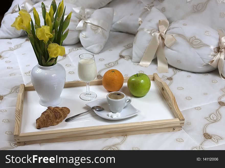 Tray with breakfast on a bed in a hotel room. Tray with breakfast on a bed in a hotel room