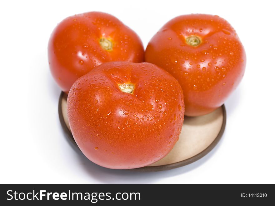 Tree ripe red tomatoes, coverd drops of water, on a plate, isolated on the white background. Tree ripe red tomatoes, coverd drops of water, on a plate, isolated on the white background