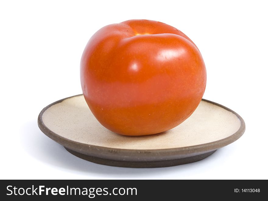 Tomato on a plate isolated on the white background