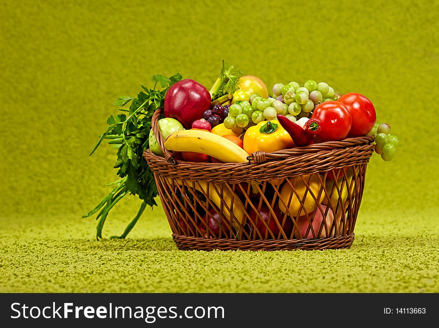 Basket full of fresh produce. green background