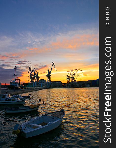 Harbor with cranes and boats at sunset. Harbor with cranes and boats at sunset