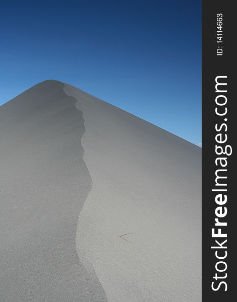 A sand dune at the Bruneau Sand Dunes of Southern Idaho rises into the clear blue sky. A sand dune at the Bruneau Sand Dunes of Southern Idaho rises into the clear blue sky.