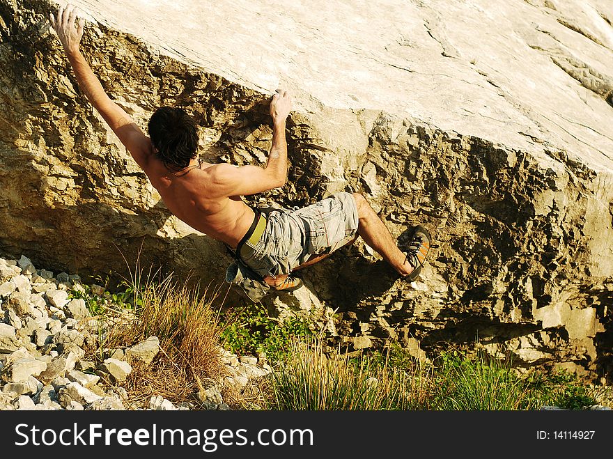 Climber reaching the next hold on a boulder climb. Climber reaching the next hold on a boulder climb