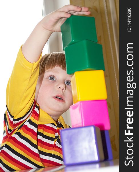 The beautiful little boy poses on a light background. The beautiful little boy poses on a light background