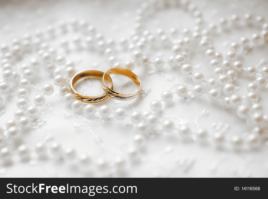 Two wedding rings on white background with beads