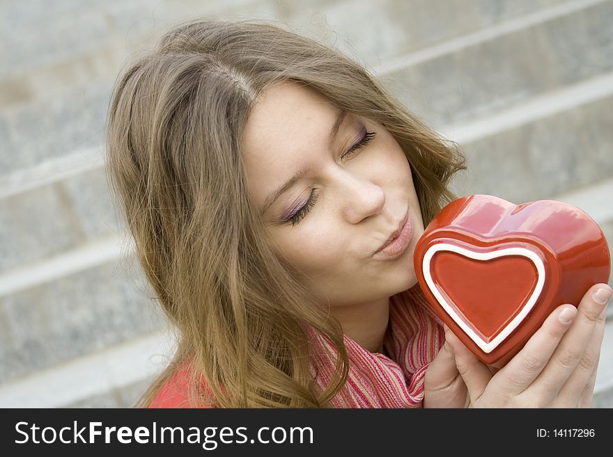 A beautiful young woman holding a red heart. Valentine. A beautiful young woman holding a red heart. Valentine