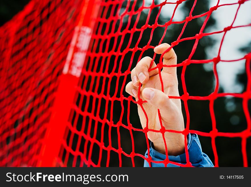 Human hand is holding red net. Human hand is holding red net