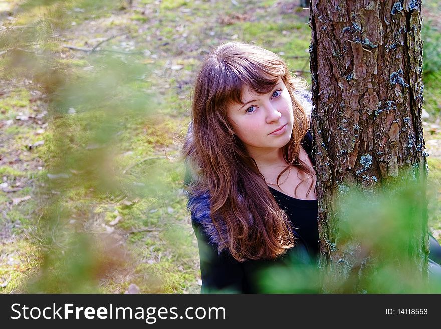 Young woman near the tree in the forest, in a sunny spring day. Young woman near the tree in the forest, in a sunny spring day